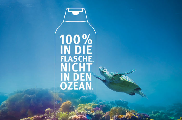 Eine Meeresschildkröte schwimmt in der Nähe eines Korallenriffs unter Wasser. Der überlagerte Text innerhalb des Umrisses einer Flasche lautet: 100 % IN DIE FLASCHE, NICHT IN DEN OZEAN. (Englisch: 100 % in die Flasche, nicht in den Ozean.) Werner & Mertz unterstützt saubere Ozeane.