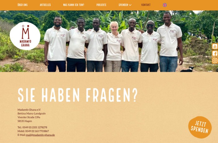 Eine Gruppe von sieben Personen, sechs Männer und eine Frau, stehen im Freien nebeneinander, lächeln und tragen zusammenpassende weiße Poloshirts mit dem Madamfo Ghana-Logo, die diese engagierte ghanaische Wohltätigkeitsorganisation repräsentieren. Darunter befindet sich ein hellbraunes Banner mit Kontaktinformationen und einem Jetzt Spenden-Button. Eine Gruppe von sieben Personen, sechs Männer und eine Frau, stehen im Freien nebeneinander, lächeln und tragen zusammenpassende weiße Poloshirts mit dem Madamfo Ghana-Logo, die diese engagierte ghanaische Wohltätigkeitsorganisation repräsentieren. Darunter befindet sich ein hellbraunes Banner mit Kontaktinformationen und einem Jetzt Spenden-Button.