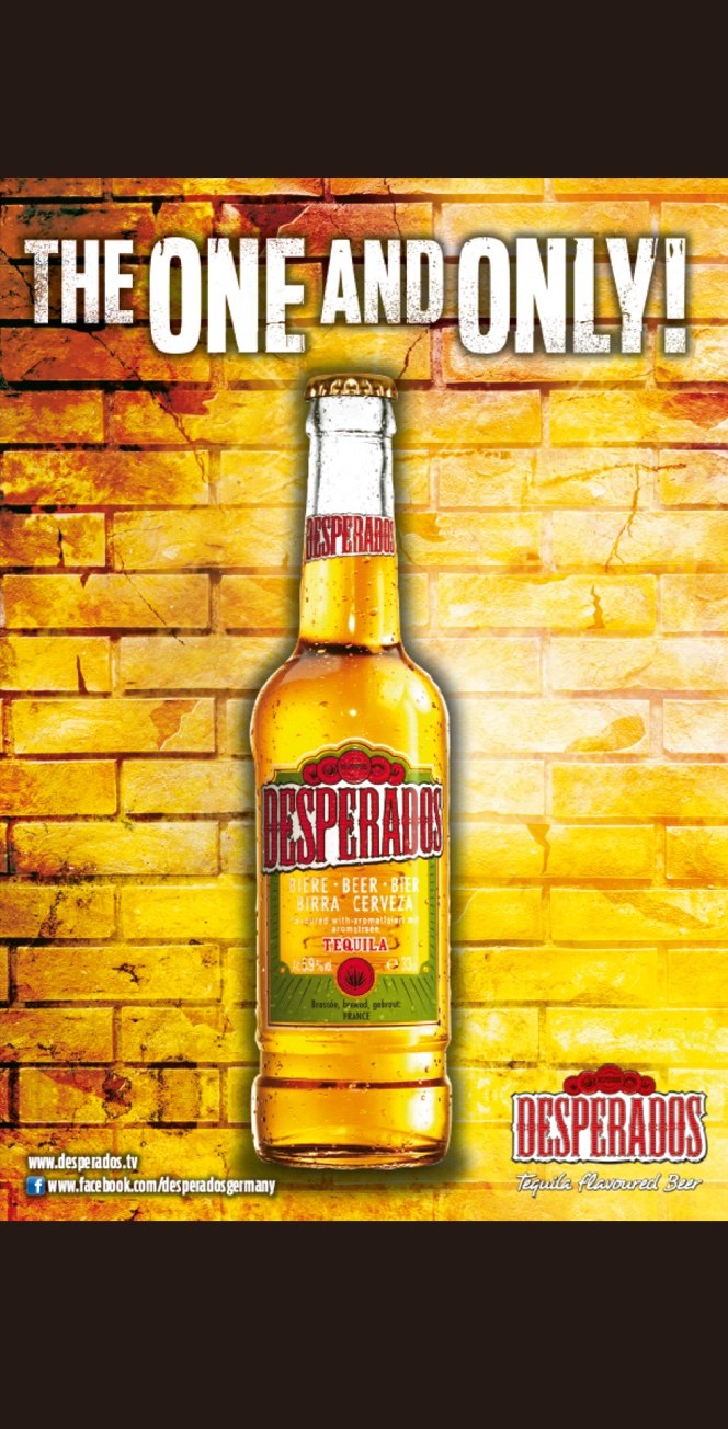Eine Flasche Desperados-Bier mit Tequila steht vor einer gelben Backsteinmauer. Darüber steht in Fettschrift THE ONE AND ONLY! und in den unteren Ecken sind die Logos von Desperados zu sehen.