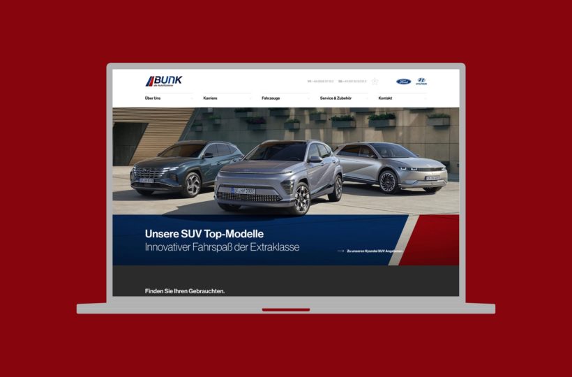 Auf einem Laptop-Bildschirm wird das Webdesign eines Autohauses angezeigt, auf der drei moderne Geländewagen nebeneinander geparkt sind. Ein Banner mit der Aufschrift "Unsere SUV Top-Modelle" ist auf blauem und rotem Hintergrund zu sehen.