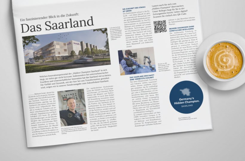 In einer Zeitschrift erschien ein Artikel mit der Überschrift "Das Saarland", auf dem ein modernes Gebäude, eine Person mit medizinischen Geräten und ein Mann im Anzug neben einer Tasse Kaffee auf einem weißen Tisch abgebildet waren.