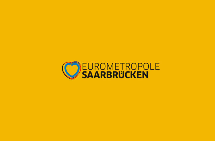 Logo auf gelbem Hintergrund mit blauem, gelbem, schwarzem und rotem Herzumriss, das Saarbrücken neben dem Text "EUROMETROPOLE SAARBRÜCKEN" hervorhebt, mit "SAARBRÜCKEN" in fetten Buchstaben.