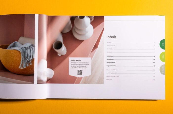 Eine aufgeschlagene Zeitschrift auf einer gelben Fläche zeigt links das Foto eines rosa Tisches mit weißen Vasen und einem orangefarbenen Korb und rechts ein deutsches Inhaltsverzeichnis mit der Aufschrift Inhalt. Am Rand sind grüne Registerkarten zu sehen. Eine aufgeschlagene Zeitschrift auf einer gelben Fläche zeigt links das Foto eines rosa Tisches mit weißen Vasen und einem orangefarbenen Korb und rechts ein deutsches Inhaltsverzeichnis mit der Aufschrift Inhalt. Am Rand sind grüne Registerkarten zu sehen.