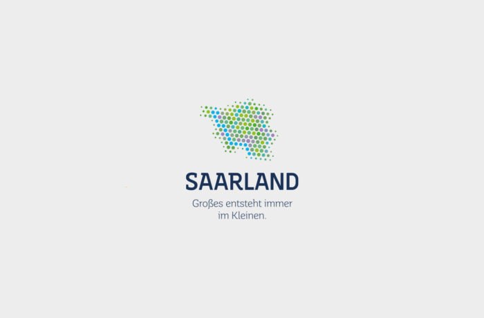 Logo mit einer Ansammlung von blauen, grünen und gelben Punkten, die die Form des Saarlandes bilden, über dem Text SAARLAND und dem deutschen Slogan Großes entsteht immer im Kleinen - moderne Logogestaltung auf hellgrauem Hintergrund.